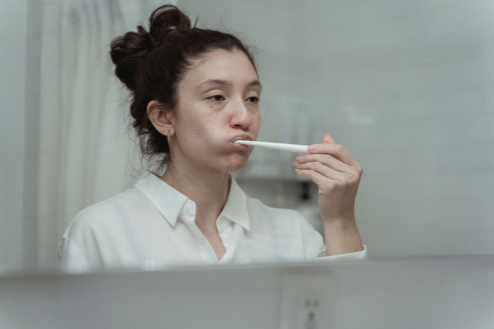 Woman brushing her teeth at home