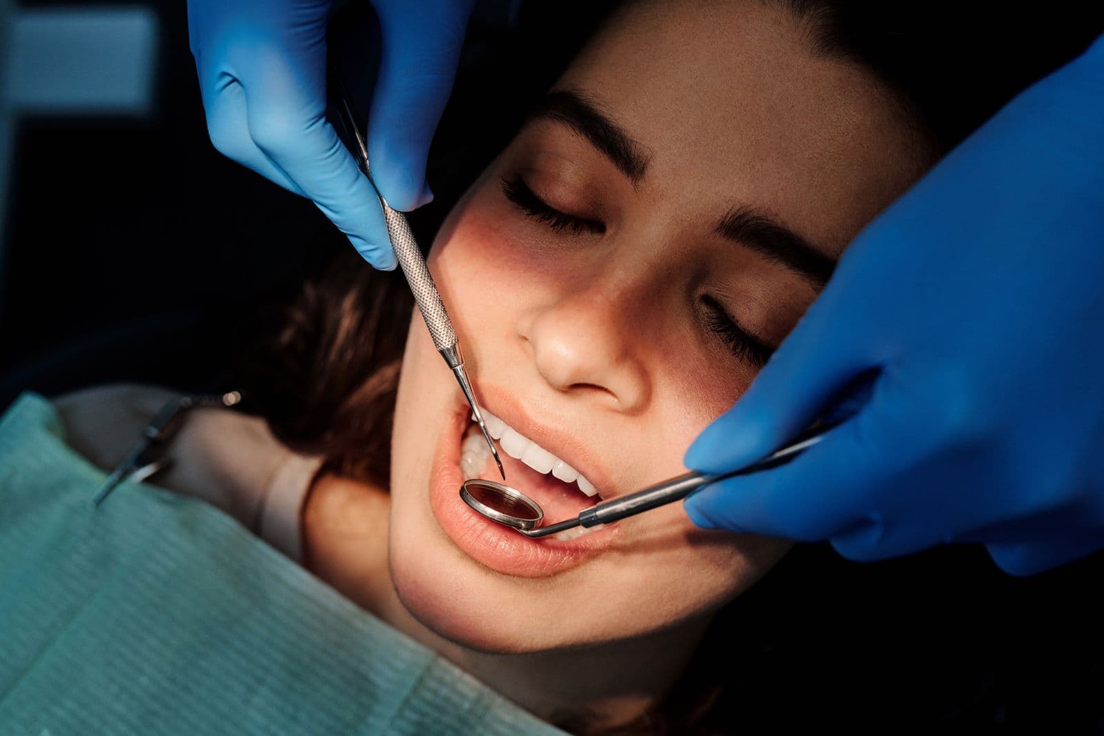 Dentist examining a patient's teeth with a mirror and probe