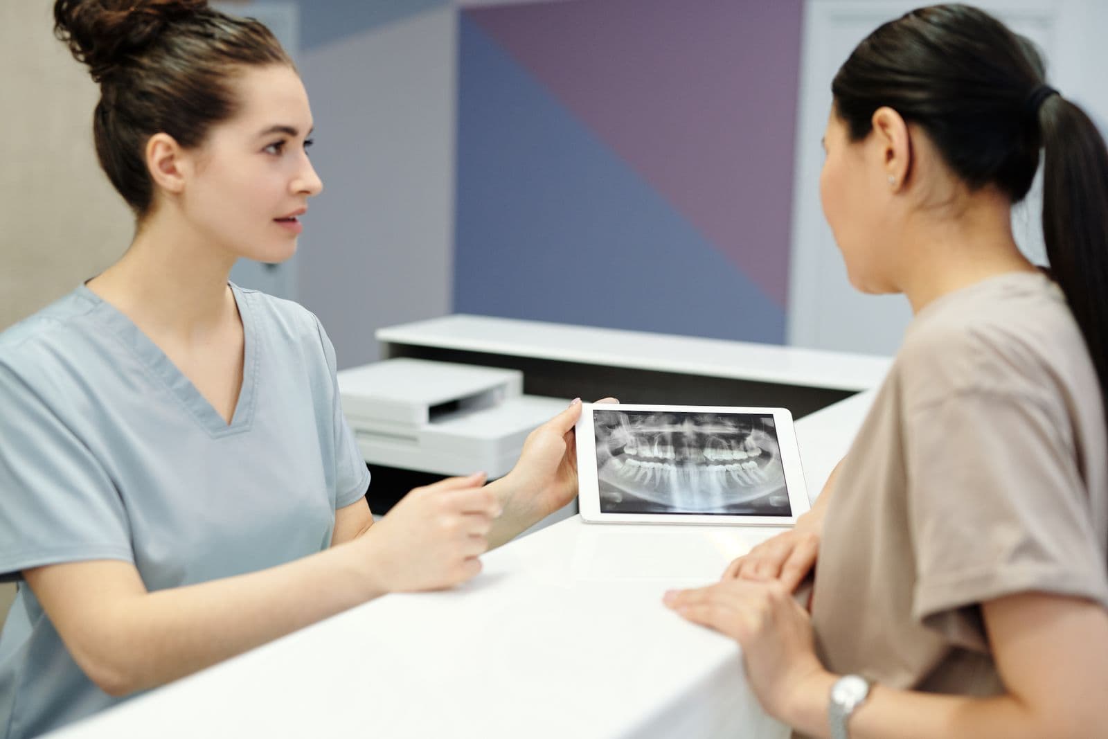 Dental professional discussing an X-ray with a patient